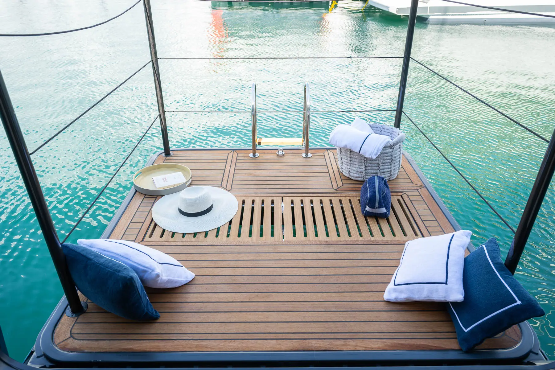 Bow lounge with cushions and trampoline nets above clear water
