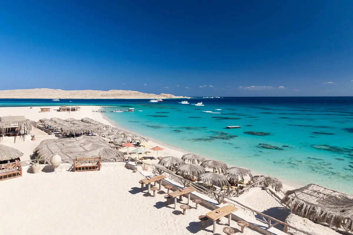 White sand beach with sunshades and turquoise water on Giftun Island
